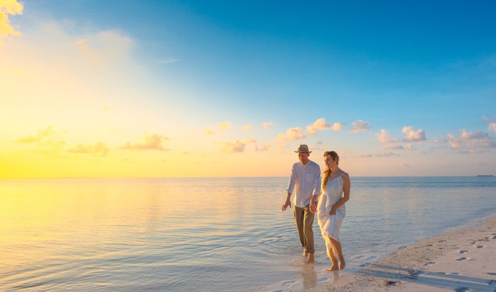 Couple Walking on Seashore Wearing White Tops during Sunset